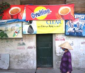 Quảng cáo ngoài trời ở Việt Nam vẫn chuộng lối truyền thống như bảng hiệu lớn gắn trên các tòa nhà, cột đèn treo băng rôn quảng cáo - Ảnh: Việt Tuấn.