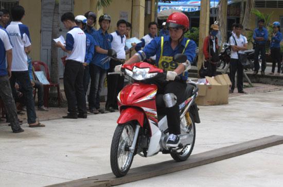 Các học viên thực hành đi xe thăng bằng trên ván hẹp.