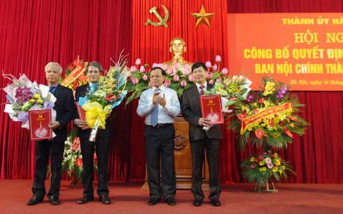 Bí thư Thành ủy Phạm Quang Nghị trao quyết định và tặng hoa cho lãnh đạo Ban Nội chính Thành ủy.<br>