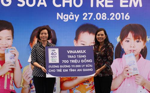 Bà Bùi Thị Hương, Giám đốc điều hành Vinamilk trao tặng bảng tượng trưng 700 triệu tương đương 111.000 ly sữa của Quỹ sữa Vươn cao Việt Nam cho trẻ em nghèo tỉnh An Giang.