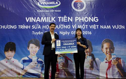 Ông Nguyễn Quốc Khánh - Giám đốc Điều hành Vinamilk - trao tặng bảng tượng trưng 1 tỷ đồng đến trẻ em tỉnh Tuyên Quang cho đại diện của tỉnh tại ngày hội sữa học đường - Ảnh: Xuân Phú.