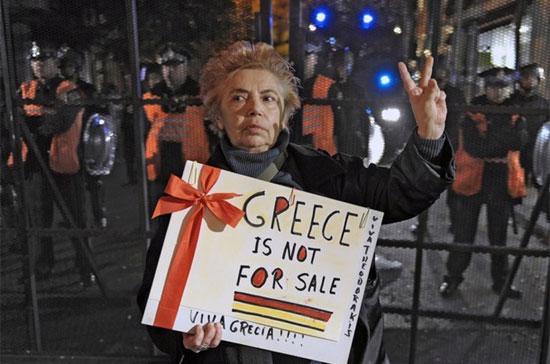 Một người biểu tình mang biểu ngữ "Hy Lạp không phải để bán" tại một cuộc tuần hành ở thủ đô Athens, Hy Lạp - Ảnh: Getty.