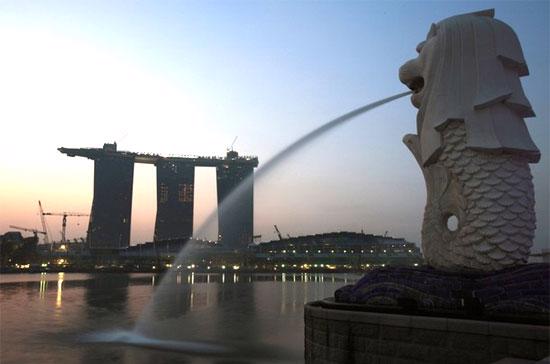 Biểu tượng sư tử của Singapore phía trước công trường Marina Bay Sands, một tổ hợp casino và resort sắp hoàn thành. Vượt lên sau suy thoái, tăng trưởng kinh tế Singapore đạt hơn 19% trong quý 2 và có thể đạt 13-15% trong cả năm nay.