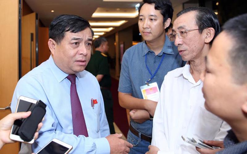 Bộ trưởng Bộ Kế hoạch và Đầu tư Nguyễn Chí Dũng trao đổi với báo chí bên hành lang Quốc hội sáng 12/6.<br>