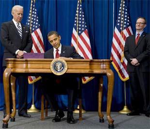Tổng thống Barack Obama ký vào bản kế hoạch mang tên Đạo luật Phục hồi và Tái đầu tư nước Mỹ - Ảnh: Reuters.