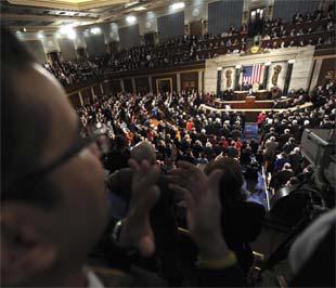 Các nghị sĩ Mỹ chào đón Tổng thống Barack Obama trước bài phát biểu đầu tiên tại Quốc hội Mỹ của ông - Ảnh: Reuters.