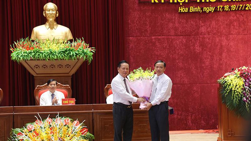 Bí thư Tỉnh ủy Hòa Bình Bùi Văn Tỉnh tặng hoa chúc mừng ông Bùi Văn Khánh (bên phải) được bầu làm Chủ tịch UBDN tỉnh Hòa Bình.