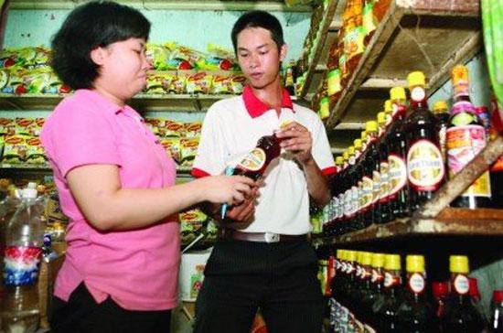  Anh Nguyễn Minh Giang, nhân viên tiếp thị của Công ty Sao Việt, cung cấp sản phẩm cho một tiểu thương ở chợ Tân Định, quận 1, Tp.HCM - Ảnh: Lê Toàn.