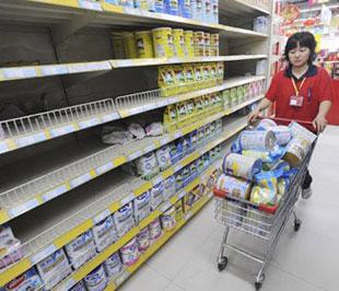 Nhân viên bán hàng đang lấy các sản phẩm sữa nhiễm độc khỏi quầy một siêu thị ở tỉnh An Huy - Ảnh: ChinaDaily.