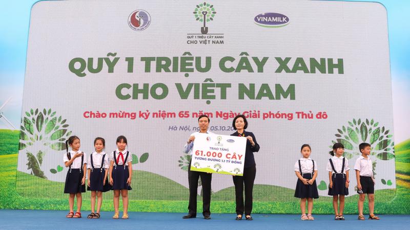 Bà Bùi Thị Hương, Giám đốc Điều hành Vinamilk trao bảng tượng trưng tặng 61.000 cây xanh của Quỹ triệu cây xanh cho Việt Nam cho đại diện thành phố Hà Nội nhân kỷ niệm 65 năm ngày Giải phóng Thủ đô.