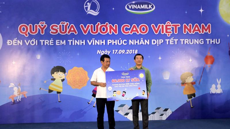 Ông Đỗ Thanh Tuấn - Giám đốc Đối Ngoại Vinamilk trao bảng tượng trưng 66.000 ly sữa cho đại diện tỉnh Vĩnh Phúc.