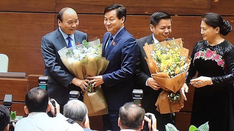 Hai thành viên mới của Chính phủ nhận hoa chúc mừng sau khi được phê chuẩn.