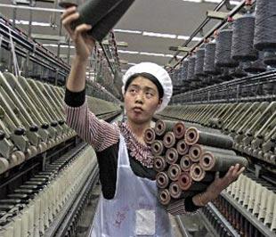 Một công nhân trong một nhà máy dệt của Trung Quốc. Có thể nói, vai trò đầu tàu của xuất khẩu đối với tăng trưởng kinh tế của Trung Quốc từ lâu đã bị thổi phồng - Ảnh: Bloomberg.