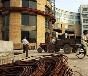 Vật liệu xây dựng đã hoen rỉ bên ngoài một trung tâm thương mại còn chưa hoàn thiện ở vùng Gurgaon, gần New Delhi, Ấn Độ.