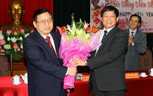 Ông Phạm Xuân Đương tặng hoa, chúc mừng ông Nguyễn Đình Phách (bên trái) đảm nhận chức vụ mới.<br>