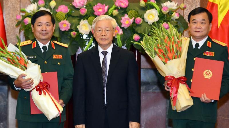 Tổng bí thư, Chủ tịch nước Nguyễn Phú Trọng trao quyết định và tặng hoa cho hai Thượng tướng.