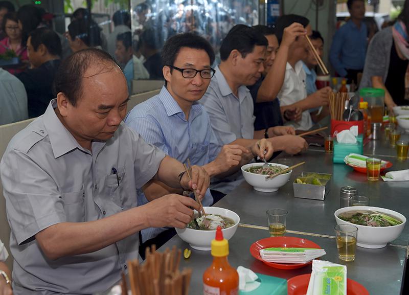 Thủ tướng Nguyễn Xuân Phúc cùng đoàn công tác Chính phủ dùng điểm tâm món phở tại một quán bình dân ở Tp.HCM.<br>