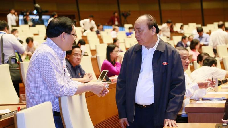 Thủ tướng trao đổi với đại biểu Quốc hôi trước phiên chất vấn sáng 8/11 - Ảnh: Quang Phúc 