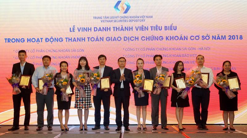 Đại diện VCBS, ông Lê Việt Hà (thứ 2 từ trái sang) - Phó giám đốc Công ty, nhận kỷ niệm chương vinh danh "VCBS là thành viên tiêu biểu trong hoạt động thanh toán giao dịch chứng khoán cơ sở năm 2018" do VSD trao tặng." 
