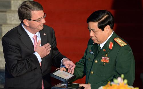 Bộ trưởng Quốc phòng Mỹ trao cuốn nhật ký và một dây thắt lưng của một người lính Việt Nam cho Bộ trưởng Quốc phòng Việt Nam Phùng Quang Thanh, tại lễ ký tuyên bố tầm nhìn chung về quan hệ quốc phòng giữa Việt Nam và Mỹ - Ảnh: BBC.<br>
