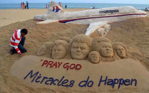 Một nghệ sỹ Ấn Độ đắp hình chuyến bay MH370 trên cát để cầu nguyện cho các hành khách và phi hành đoàn - Ảnh: Reuters.<br>