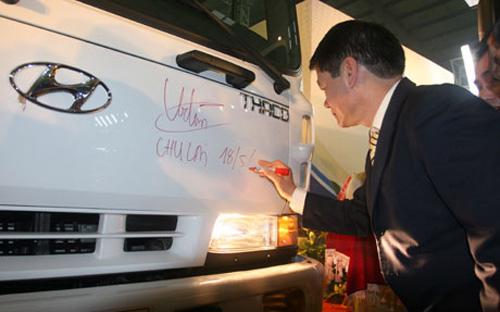Người đứng đầu Thaco Group, ông Trần Bá Dương ký tên vào cabin một xe tải Hyundai do Thaco lắp ráp.