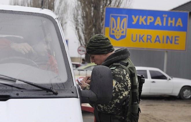 Lực lượng Biên phòng Ukraine kiểm tra giấy tờ người dân qua lại biên giới với Nga - Ảnh: Itar-Tass.<br>