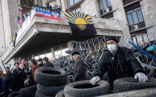 Người biểu tình chiếm giữ tòa nhà chính quyền ở Donetsk ngày 7/4 - Ảnh: EPA.<br>