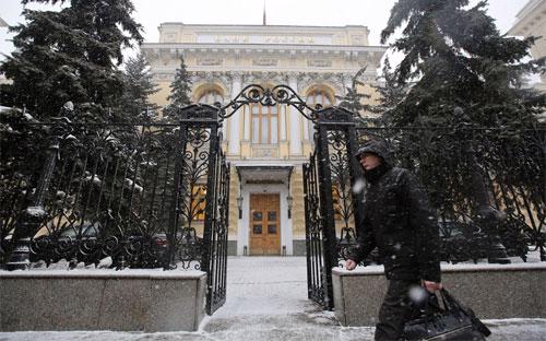 Một người bộ hành đi ngang qua trụ sở Ngân hàng Trung ương Nga ở Moscow hôm 30/1/2015 - Ảnh: Bloomberg.<br>