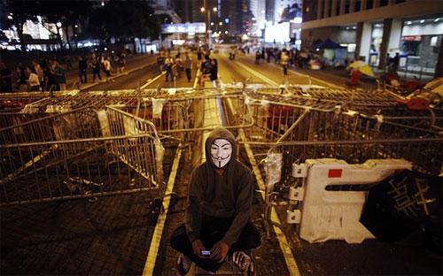 Một người biểu tình Hồng Kông ngồi trước rào chắn trên đường phố hồi đầu tháng 10 - Ảnh: Reuters/WSJ.<br>