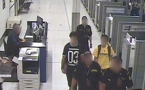 Hai thanh niên người Australia (áo có số và áo vàng) bị bắt tại sân bay khi đang tìm cách ra nước ngoài đầu quân cho IS - Ảnh: EPA/BBC.<br>