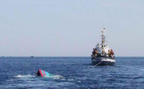 Lai dắt về đất liền tàu cá của Việt Nam bị tàu Trung Quốc đâm chìm trên biển Đông - Ảnh: Reuters.<br>