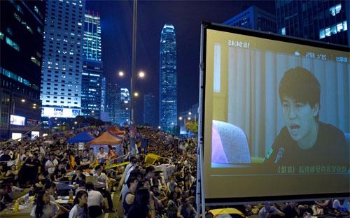 Người biểu tình Hồng Kông tập trung ở khu Mong Kok tối qua để theo dõi cuộc đàm phán được truyền hình trực tiếp - Ảnh: AP/WSJ.<br>