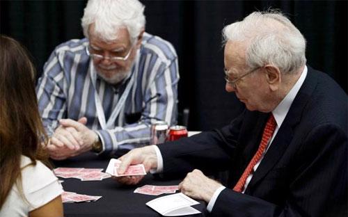 Warren Buffett (phải) chơi bài với cổ đông trong hội nghị cổ đông thường niên của Berkshire Hathaway ở Omaha, Nebraska ngày 3/5 - Ảnh: Reuters.<br>