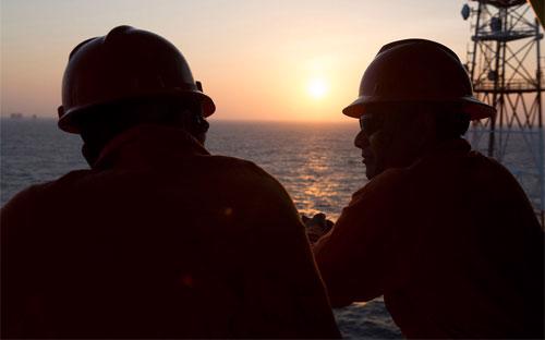 Hai công nhân dầu khí trên một giàn khoan trên vịnh Mexico - Ảnh: Bloomberg.<br>