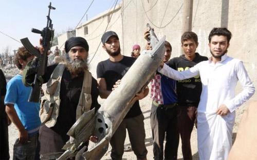 Một chiến binh Nhà nước Hồi giáo (trái) bên cư dân địa phương ở Raqqa, Syria, hôm 16/9 - Ảnh: Reuters.<br>