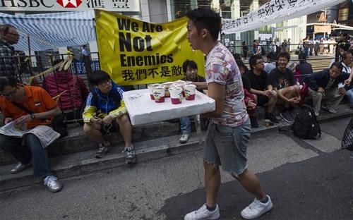 Một thanh niên Hồng Kông phát trà cho những người biểu tình đòi dân chủ trên đường phố ngày 7/10 - Ảnh: AFP/Getty.<br>