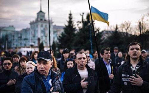 Người dân ở thành phố Lugansk thuộc miền Đông Ukraine hát quốc ca trong một cuộc tuần hành ủng hộ Chính phủ - Ảnh: AFP/Getty.<br>