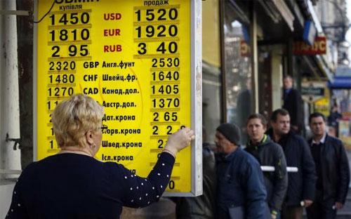 Bảng thông báo tỷ giá bên ngoài một điểm giao dịch ngoại tệ ở Kiev ngày 10/11. Đồng Hryvnia của Ukraine đang mất giá mạnh - Ảnh: Reuters.<br>