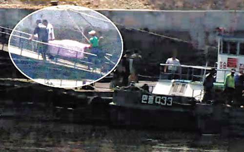 Một nạn nhân trong vụ máy bay phát nổ đang được đưa ra khỏi hiện trường - Ảnh được cắt từ clip trên kênh truyền hình KBS/ Nguồn: Chosun Ilbo.<br>