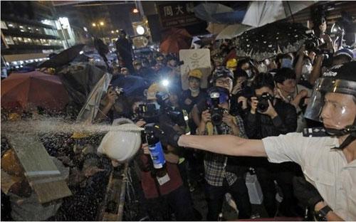 Người biểu tình Hồng Kông lao vào tấn công cảnh sát, trong khi cảnh sát dùng dùi cui và bình xịt hơi cay để tấn công lại - Ảnh: AP/BBC.<br>