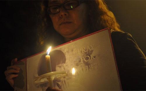 Một phụ nữ Malaysia cầu nguyện cho các hành khách trên chuyến bay mất tích MH370 hôm 10/3 tại Kuala Lumpur - Ảnh: Zuma.<br>