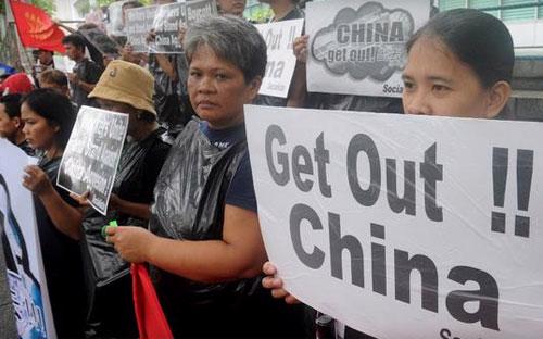 Người dân Philippines tập trung trước lãnh sự quán Trung Quốc ở quận tài chính ở Manila để bày tỏ sự phản đối Bắc Kinh trong vấn đề biển Đông ngày 10/7 - Ảnh: Getty/CBS.<br>