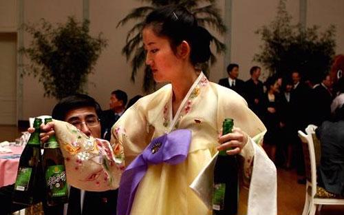 Một nữ nhân viên phục vụ đang tiếp bia tại một bữa tiệc chiêu đãi do Chính phủ Triều Tiên tổ chức ở Bình Nhưỡng - Ảnh: CNBC/Getty.<br>