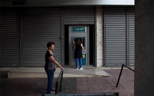 Người Hy Lạp rút tiền ở một ATM tại thủ đô Athens ngày 19/7 - Ảnh: Reuters.<br>