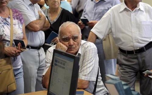 Một người hưu trí Hy Lạp đang chờ nhận một phần lương hưu tại chi nhánh ngân hàng National Bank trên đảo Crete, Hy Lạp ngày 2/7 - Ảnh: Reuters.<br>