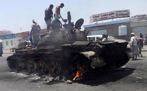 Một chiếc xe tăng bị phá hủy trên đường phố ở thành phố cảng miền Nam Yemen - Ảnh: Reuters.<br>