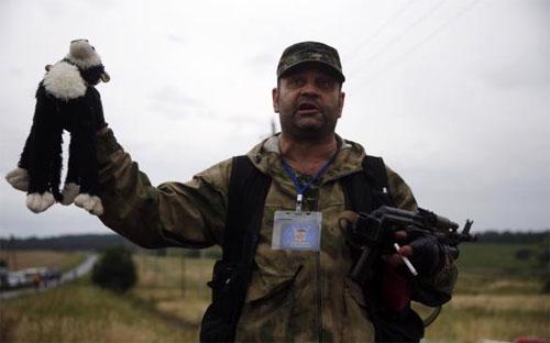 Một dân quân thân Nga đứng ở hiện trường vụ máy bay MH17 rơi ở Đông Ukraine - Ảnh: Reuters.<br>