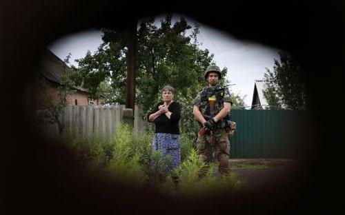 Lính Ukraine đứng cạnh một người dân tại làng Semenovka, gần Sloviansk, Đông Ukraine - Ảnh: Reuters.