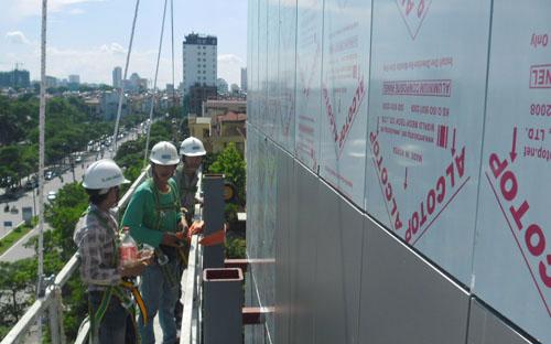 Một nhóm thợ đang hoàn thiện mặt ngoài của Lotte Center Hanoi<br>